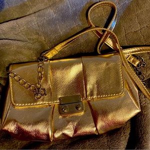 Gold vinyl clutch bag with chain/gold strap tucks away in small inside pocket.